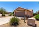 Side exterior view showcasing the two-car garage, neutral color scheme, and desert landscaping at 10521 W Donald Dr, Peoria, AZ 85383