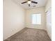 This bedroom boasts carpet, a ceiling fan and light, and a sliding closet door at 10722 W Quartz Dr, Casa Grande, AZ 85193