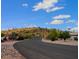 Neighborhood street showcases desert landscape with a view of mountains and a blue sky at 10722 W Quartz Dr, Casa Grande, AZ 85193
