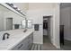 Bright bathroom with dual sinks, modern vanity, walk-in closet and shower with glass door at 11224 W Puget Ave, Peoria, AZ 85345