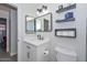 This bathroom offers a large, bright mirror and floating shelves for storage at 11224 W Puget Ave, Peoria, AZ 85345