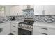 Well-lit kitchen boasts quartz countertops, stainless steel oven and range, and modern backsplash at 11224 W Puget Ave, Peoria, AZ 85345