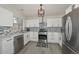 Modern kitchen boasts stainless steel appliances, granite countertops, stylish mosaic backsplash, and ample white cabinetry at 11224 W Puget Ave, Peoria, AZ 85345