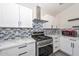 Modern kitchen features stainless steel oven and range, quartz countertops, and sleek white cabinets at 11224 W Puget Ave, Peoria, AZ 85345