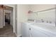 This laundry room provides a shelf for storage and modern, white washer and dryer at 11224 W Puget Ave, Peoria, AZ 85345