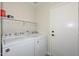 This laundry room provides a shelf for storage and modern, white washer and dryer at 11224 W Puget Ave, Peoria, AZ 85345