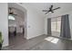 Bright living room with gray wood floors, a ceiling fan, neutral walls, and light filtering through the window at 11224 W Puget Ave, Peoria, AZ 85345
