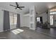 Open-concept living space with gray wood floors, large windows, and stylish décor flowing into the living area at 11224 W Puget Ave, Peoria, AZ 85345