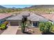 Expansive aerial view of desert home with lush landscaping and stunning mountain backdrop at 11796 W Creosote Dr, Peoria, AZ 85383