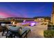 Picture-perfect outdoor living space with pool, spa, lounge chairs, and an outdoor kitchen under a colorful sky at 11796 W Creosote Dr, Peoria, AZ 85383