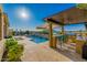 Outdoor kitchen with a built-in BBQ, bar seating and a beautiful view of the pool and surrounding landscape at 11796 W Creosote Dr, Peoria, AZ 85383