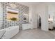 Spacious bathroom featuring a soaking tub, chandelier, and patterned accent wall at 11796 W Creosote Dr, Peoria, AZ 85383