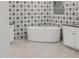 Elegant bathtub with a decorative tile wall and modern fixtures at 11796 W Creosote Dr, Peoria, AZ 85383