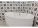 Close-up of a soaking tub with a decorative tile accent wall and brushed nickel fixtures at 11796 W Creosote Dr, Peoria, AZ 85383