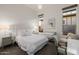 Elegant bedroom featuring a tufted headboard, mirrored nightstands, and a cozy seating area at 11796 W Creosote Dr, Peoria, AZ 85383