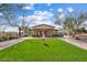 Exterior view of a clubhouse featuring a well-manicured lawn and a charming fountain at 11796 W Creosote Dr, Peoria, AZ 85383
