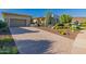Exterior view of home highlighting the driveway, desert landscaping, and the three-car garage at 11796 W Creosote Dr, Peoria, AZ 85383