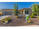 Beautiful exterior view of home featuring desert landscaping, a three-car garage, and a stone facade at 11796 W Creosote Dr, Peoria, AZ 85383