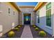 Inviting front entrance featuring a brick walkway, desert landscaping with barrel cactus, and a modern glass-paneled front door at 11796 W Creosote Dr, Peoria, AZ 85383