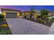 Well-manicured front yard featuring a home with desert landscaping and a paved driveway at dusk at 11796 W Creosote Dr, Peoria, AZ 85383
