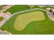 Aerial view of a vibrant green on a golf course, showcasing manicured lawns and mature trees, ideal for leisure at 11796 W Creosote Dr, Peoria, AZ 85383