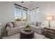 Comfortable living room with large windows, plush seating, and stylish decor at 11796 W Creosote Dr, Peoria, AZ 85383