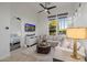 Bright living room with a comfortable sofa, large windows, and a view into the bedroom at 11796 W Creosote Dr, Peoria, AZ 85383