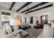 Open-concept living room featuring exposed beams, comfortable seating, and stylish decor at 11796 W Creosote Dr, Peoria, AZ 85383