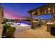 Relax and dine in this backyard showcasing a luxurious pool, outdoor kitchen, and stunning sunset views at 11796 W Creosote Dr, Peoria, AZ 85383