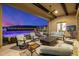 An expansive covered patio with seating, a ceiling fan, and views of the pool and surrounding landscape at 11796 W Creosote Dr, Peoria, AZ 85383