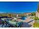 A luxurious swimming pool with water features and comfortable seating under blue skies at 11796 W Creosote Dr, Peoria, AZ 85383