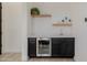 Stylish wet bar with a built-in beverage cooler, shelving, and modern finishes at 11796 W Creosote Dr, Peoria, AZ 85383