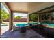 Cozy covered patio with a fire pit and comfortable seating area overlooking the refreshing pool at 1204 S Arroya Cir, Mesa, AZ 85206