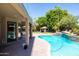 Serene backyard oasis with a pool, lush landscaping, and covered outdoor living spaces at 1204 S Arroya Cir, Mesa, AZ 85206