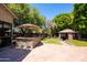Outdoor kitchen with a built-in grill, bar seating, and a charming cabana for relaxing and entertaining at 1204 S Arroya Cir, Mesa, AZ 85206