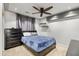 Stylish bedroom with plush blue bedding, ceiling fan, and dark wood accents at 1204 S Arroya Cir, Mesa, AZ 85206