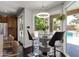Chic dining nook with a glass table, modern chairs, and views of the lush backyard and pool area at 1204 S Arroya Cir, Mesa, AZ 85206