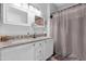 Bathroom with double vanity, granite countertop, white cabinets, and updated fixtures at 15971 W Indigo Ln, Surprise, AZ 85374