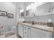 Bathroom featuring double sinks, granite countertops, white cabinets, and modern vanity lighting at 15971 W Indigo Ln, Surprise, AZ 85374