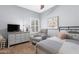 Comfortable bedroom with neutral tones, chair, and a dresser with a TV on top at 15971 W Indigo Ln, Surprise, AZ 85374