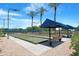 Well-maintained bocce ball courts in a landscaped community recreation area with blue canopies at 15971 W Indigo Ln, Surprise, AZ 85374