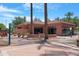 Inviting clubhouse exterior with twin palm trees, manicured landscaping, and convenient parking at 15971 W Indigo Ln, Surprise, AZ 85374