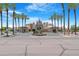 Impressive community entrance featuring lush landscaping, mature palm trees, and a welcoming sign at 15971 W Indigo Ln, Surprise, AZ 85374