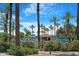 Community pool area with shade umbrellas surrounded by beautiful landscaping and palm trees at 15971 W Indigo Ln, Surprise, AZ 85374
