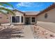 Home exterior featuring a charming entrance with desert landscaping and a cozy bench at 15971 W Indigo Ln, Surprise, AZ 85374