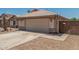 Charming single-story home with a two-car garage, desert landscaping, and a tile roof at 16333 W Paradise Ln, Surprise, AZ 85388