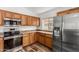 Well-lit kitchen with wood cabinets, stainless steel appliances, and modern flooring at 16333 W Paradise Ln, Surprise, AZ 85388