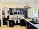 Kitchen featuring dark cabinetry, stainless steel appliances, granite countertops, and a window above the sink at 1853 N Rowen Cir, Mesa, AZ 85207