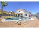 Backyard pool with rock features, mature landscaping, and a covered patio is great for summer entertaining at 1853 N Rowen Cir, Mesa, AZ 85207