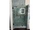 Modern shower with blue marble tile, glass enclosure, rain shower head, and accent tile at 1853 N Rowen Cir, Mesa, AZ 85207